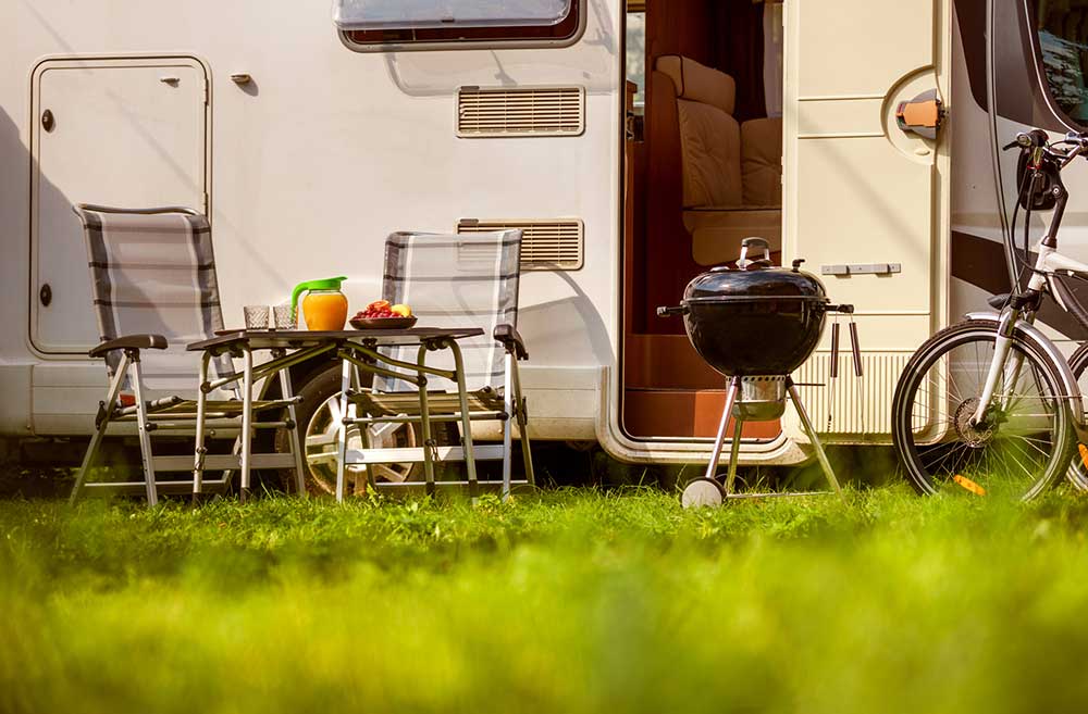 Chairs, grill, and bicycle outside of a motorhome seen while preforming RV inspection services